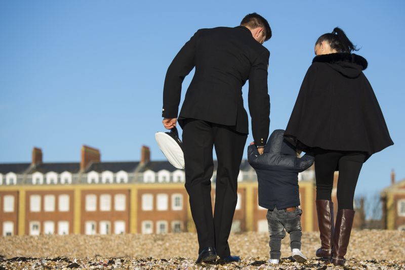 decorative image of a serviceman and his partner with a small child