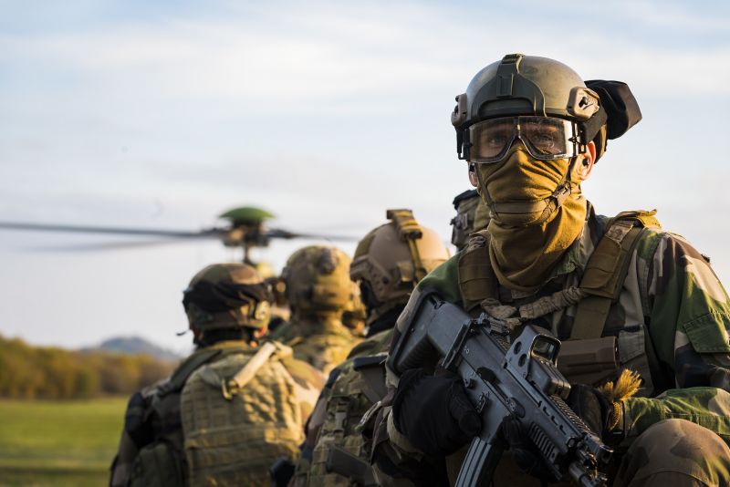 decorative image of active servicemen in front of a helicopter